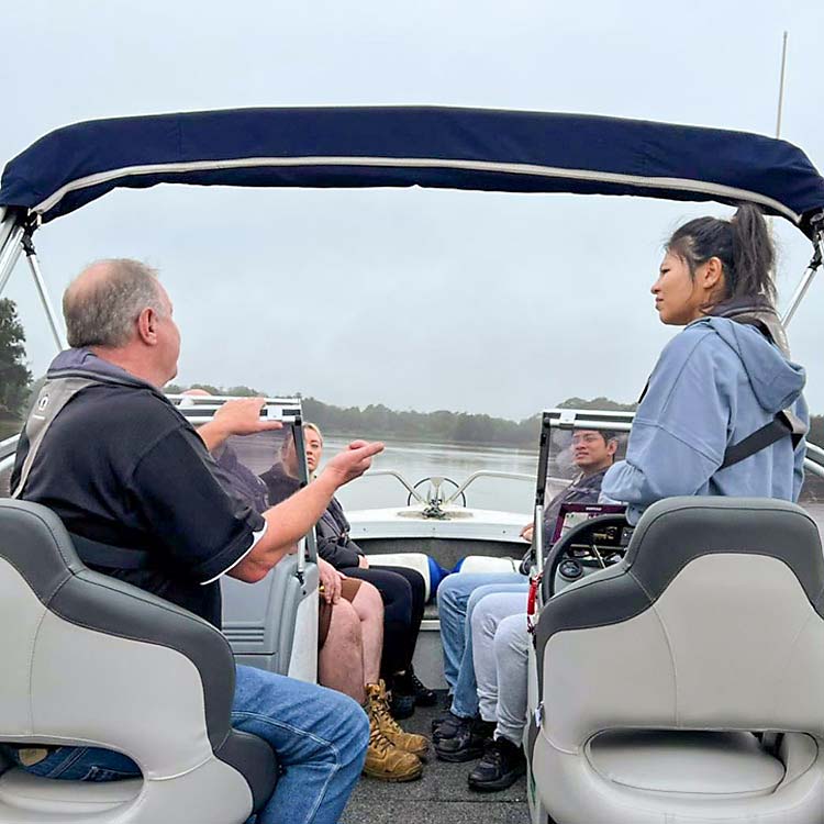 A Boating Instructor delivering training to a group of students on a boat