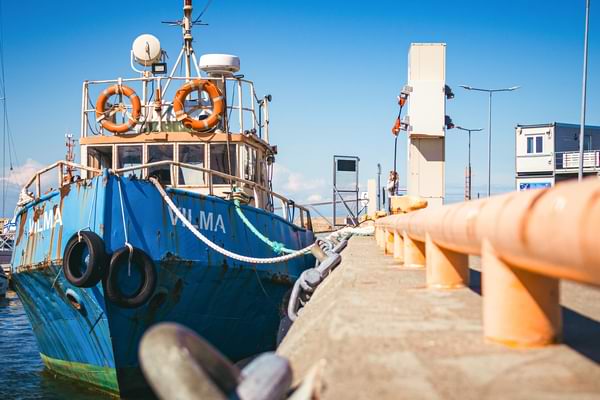 A marina with a commercial work boat beside a concrete pier