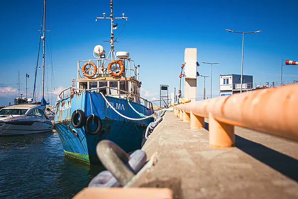 A marina with a commercial work boat beside a concrete pier